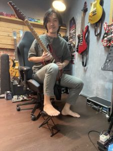 guitarist sitting on a gaming chair with footstool
